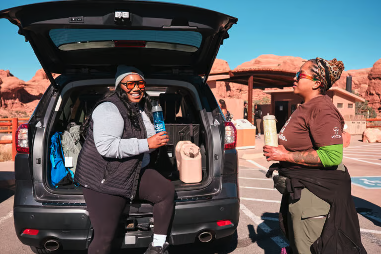 Two people talking at the back of an open Subaru hatchback