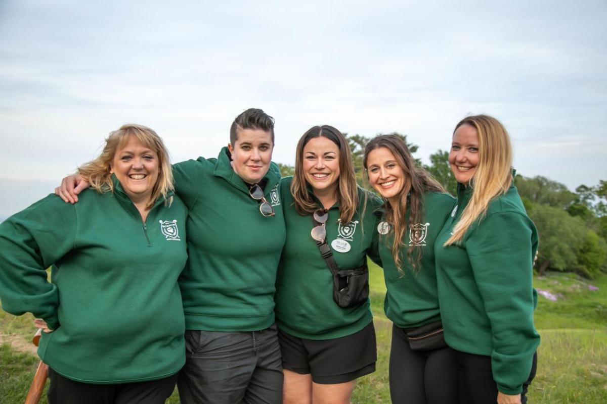 Four people in green standing together outside