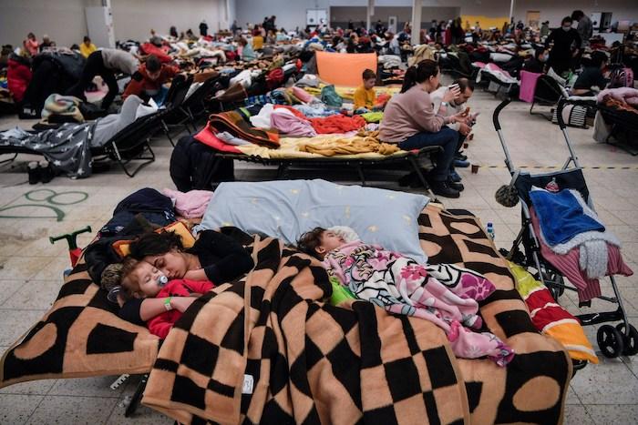 Ukrainian refugees, women and children, sleeping in a gymnasium. 