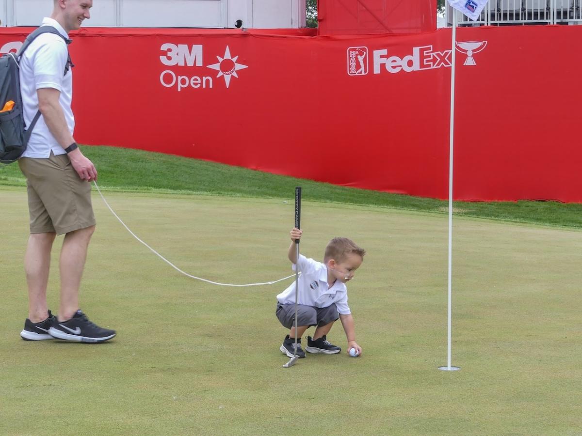 Cameron shown on the golf green with his dad.