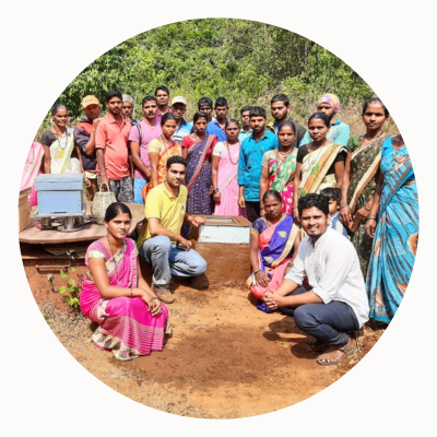 a group of people next to enclosed bee hives