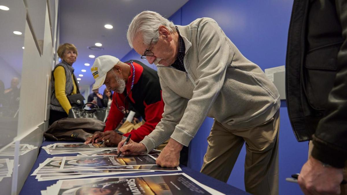 People signing posters 