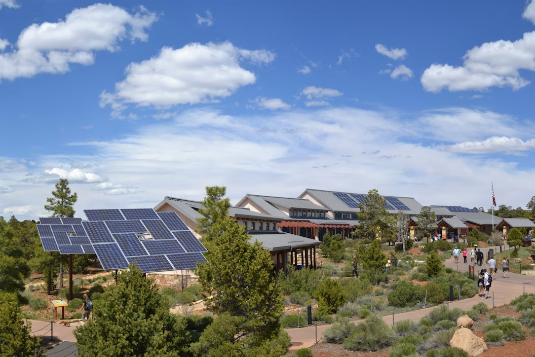 Buildings with solar panels, with a cloudy blue sky above