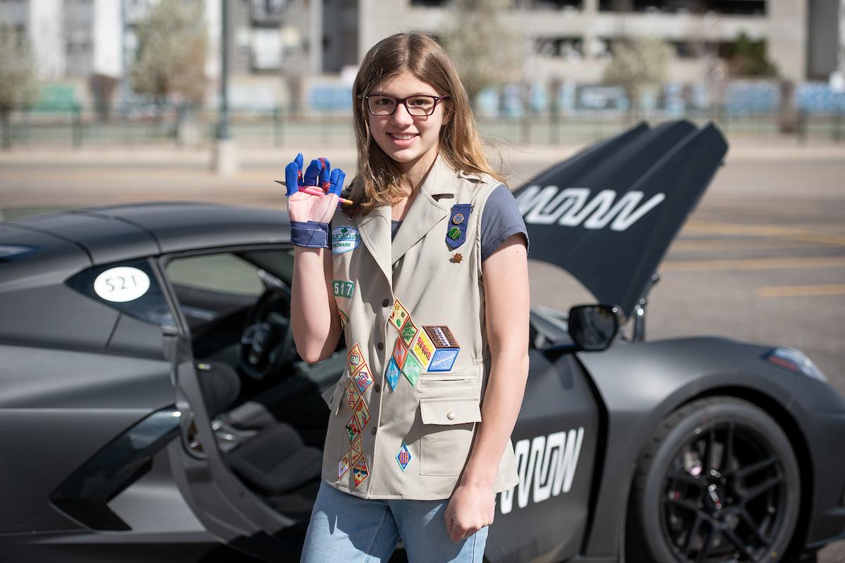 Clemetsen poses with the Helping Hand Glove in front of the SAM car