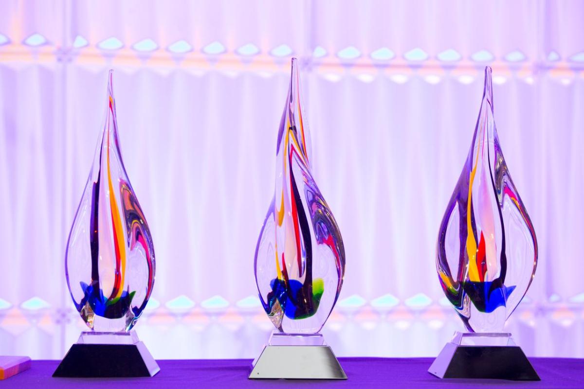 Three large glass awards arranged on a table