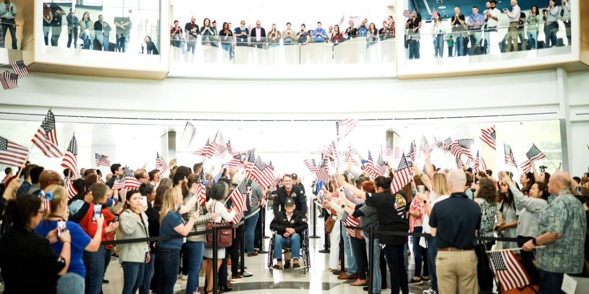 A large group of people waving American flags 