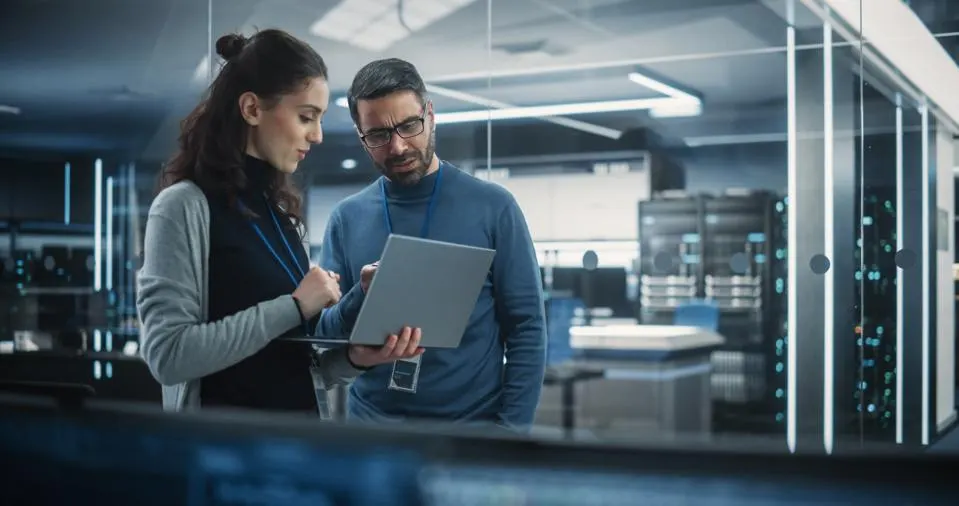 Two people looking at a laptop