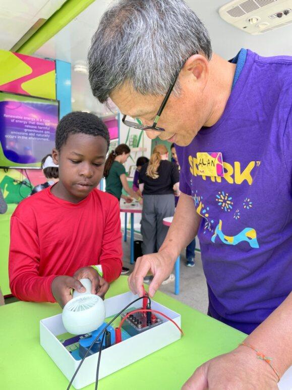 A MilliporeSigma employee teaches a student about the lifecycle of a t-shirt though an interactive experiment.