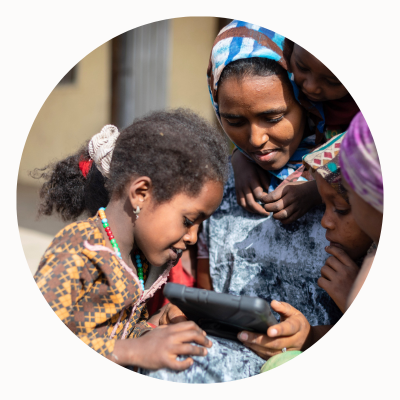 children and an adult looking at a tablet