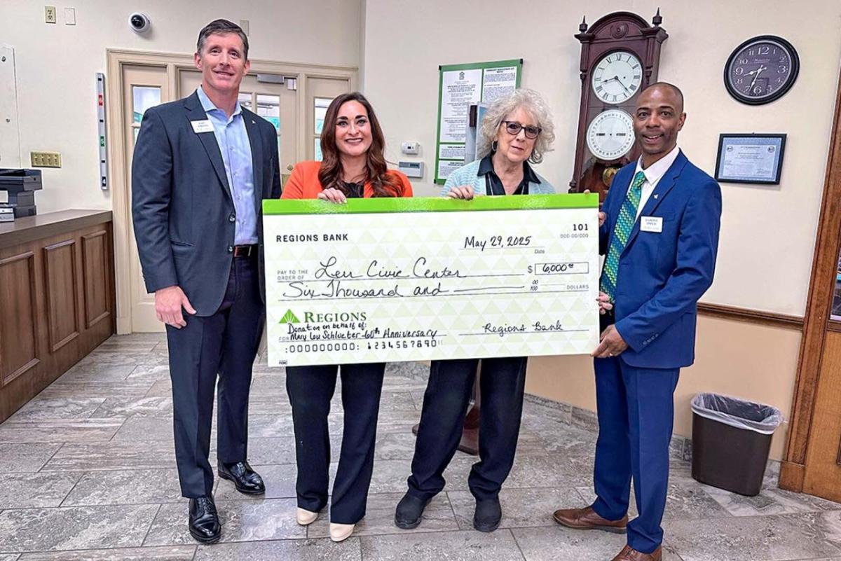 4 people holding a large check
