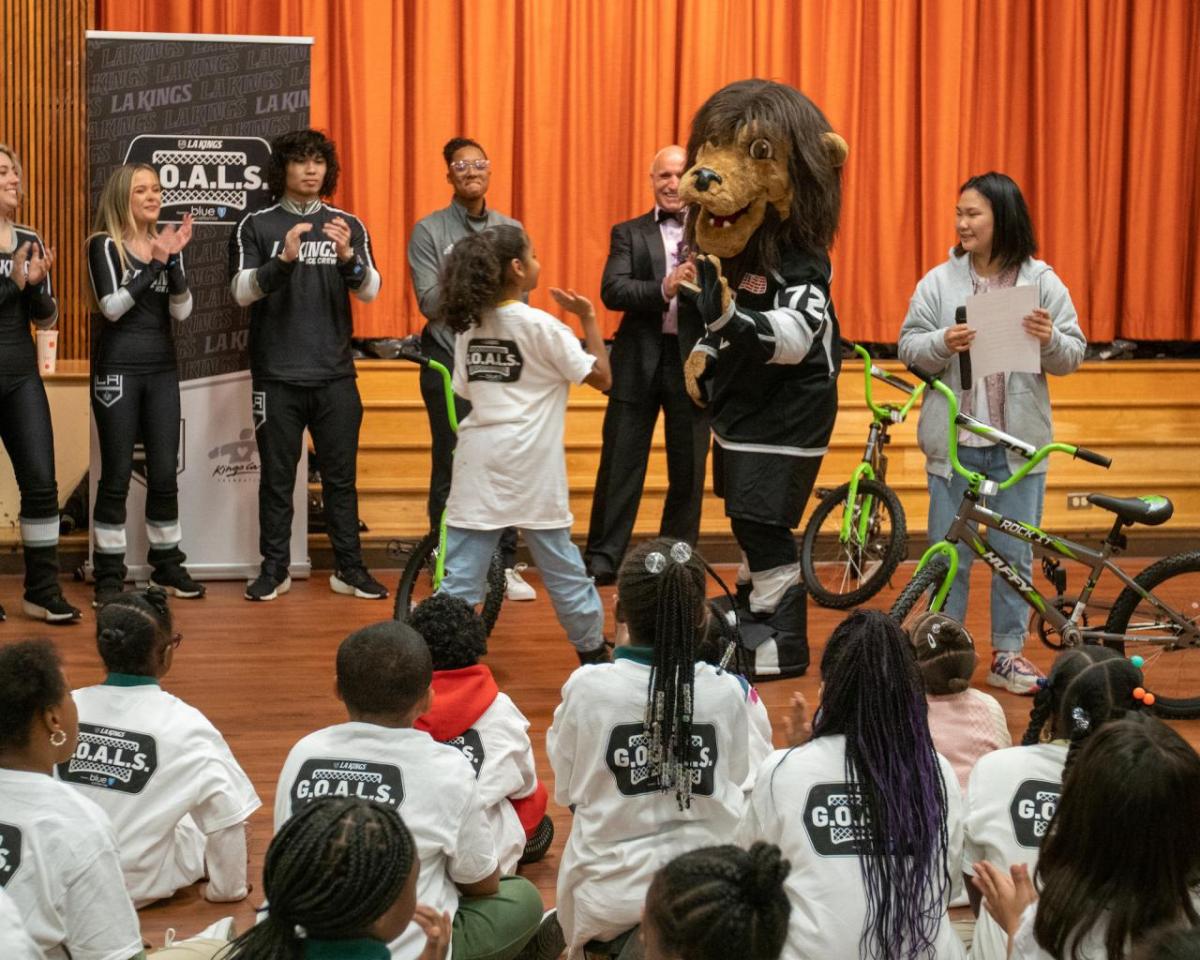 LA Kings mascot Bailey high-fives a student.