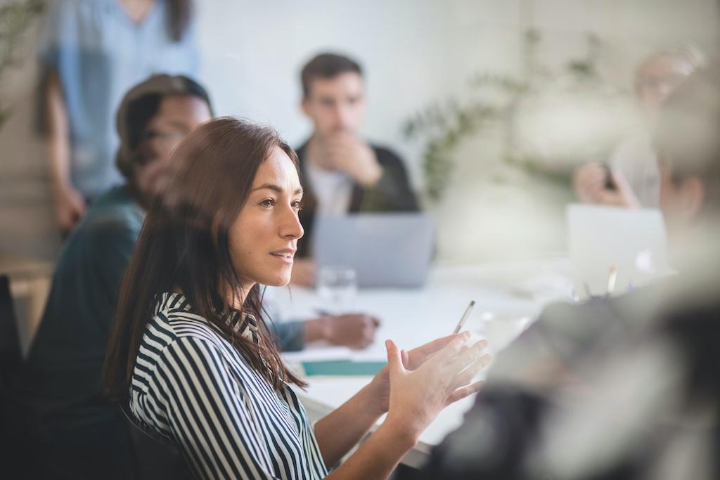 a women speaking during a meeting [Image Credit: Adobe]