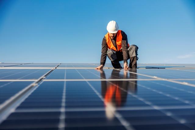 Worker installing solar panels