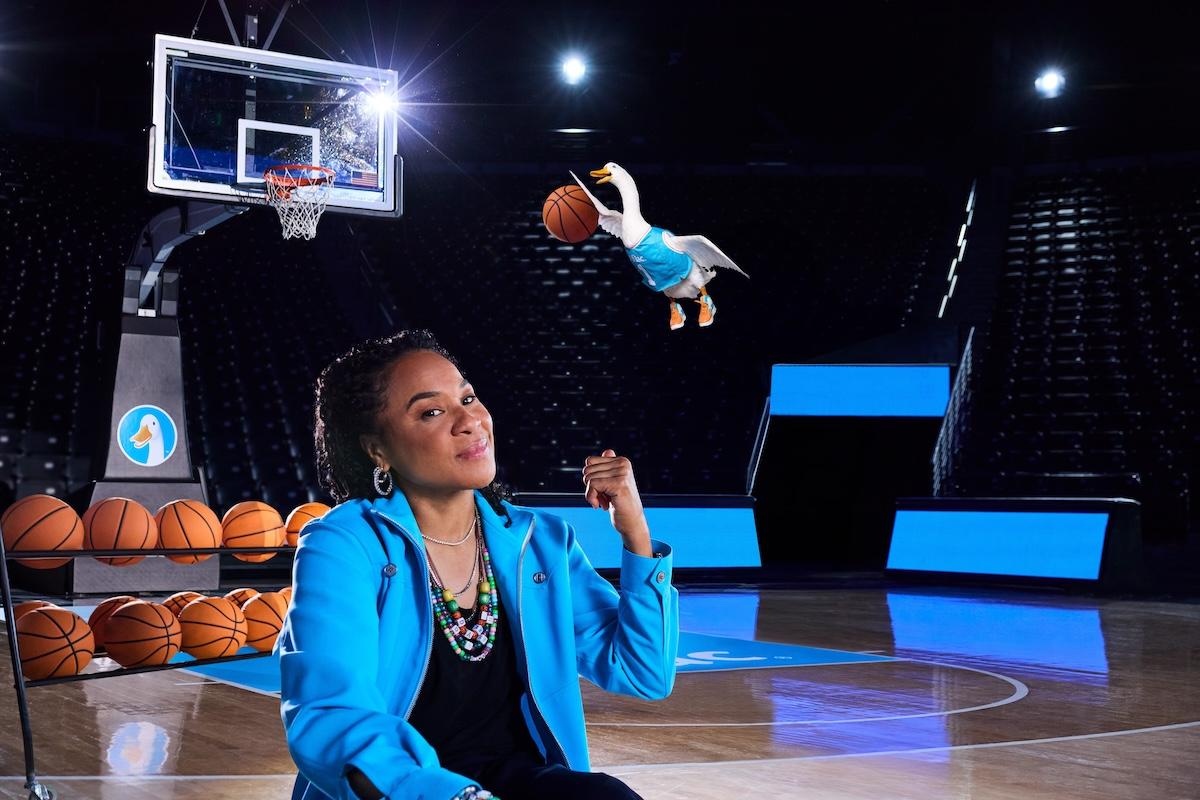 Dawn Staley and the Aflac Duck shown slam dunking a basketball.