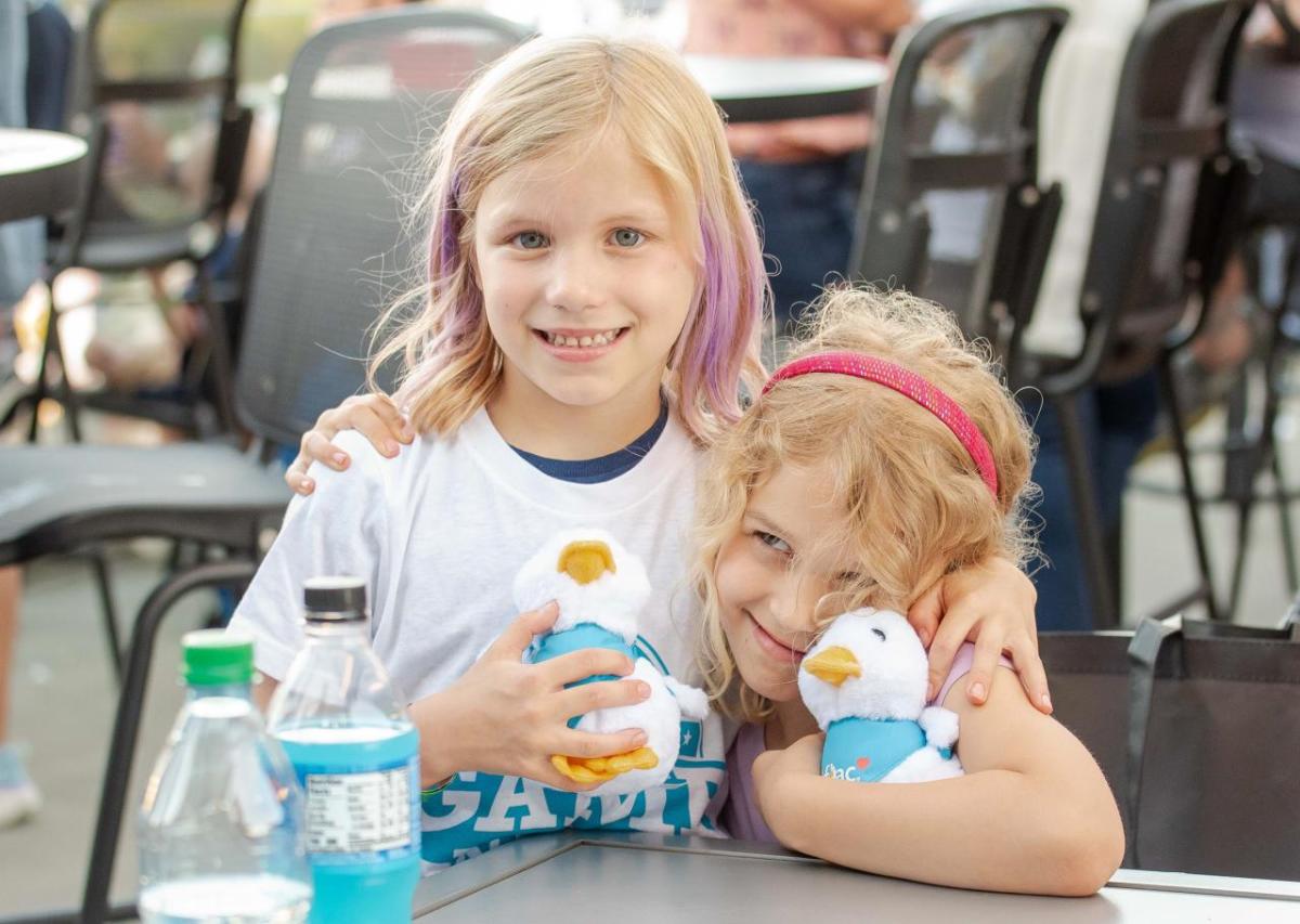 Two children at the Night of Baseball holding Aflac Ducks.