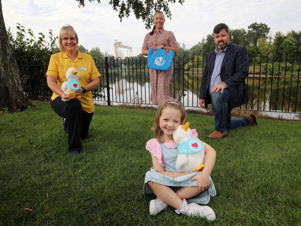 Girl seated holding Aflac duck.