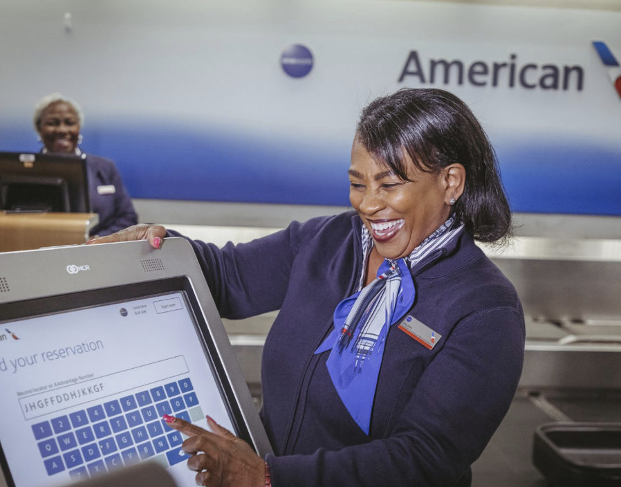 An airport staff member looking up a reservation on a screen 