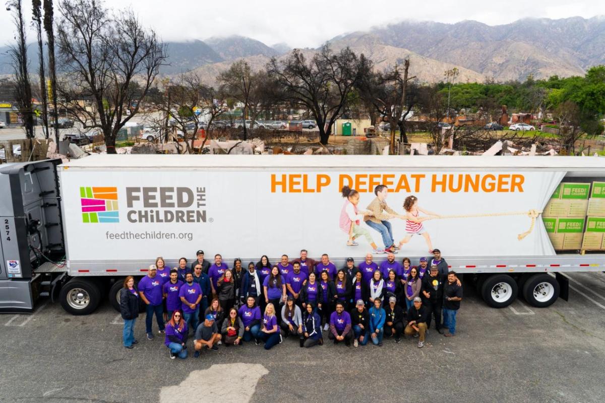 Group picture of volunteers in front of Feed the Children Truck