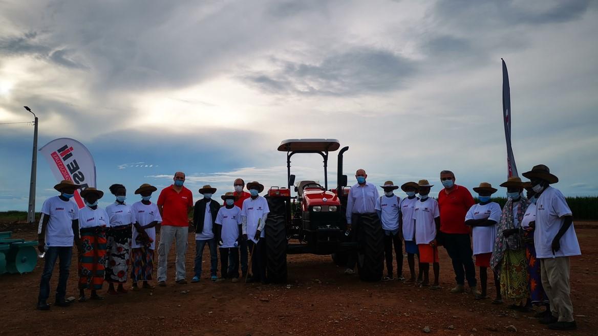 group standing around donated tractor