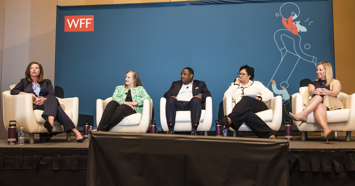 5 people sit on stage with WFF backdrop behind them