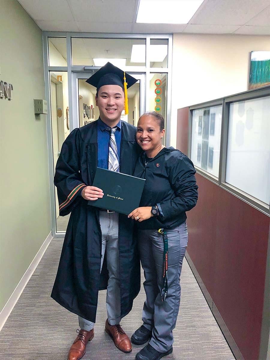 Austin stood next to someone in a graduation gown and cap 