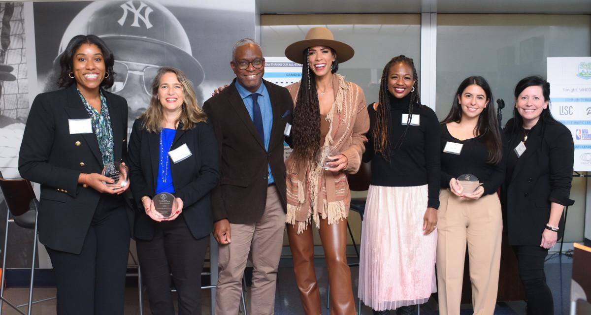 Group of people in a row, some holding awards