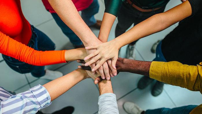 Woman putting their hands together in a circle; like they are taking an oath.