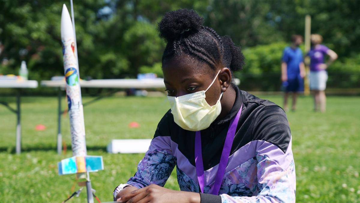 Science Club for Girls scientist, Jhianna, examining her rocket before its launch