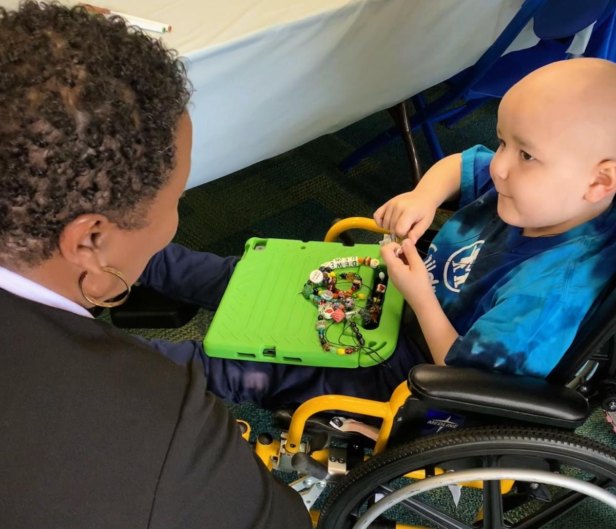 Aflac volunteers helping Dewey pick out even more beads to add to his collection.