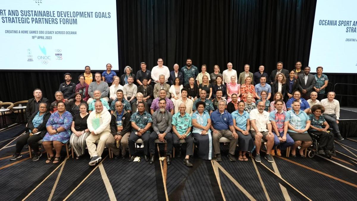 diverse group of people sitting and standing in 4 rows on a convention stage