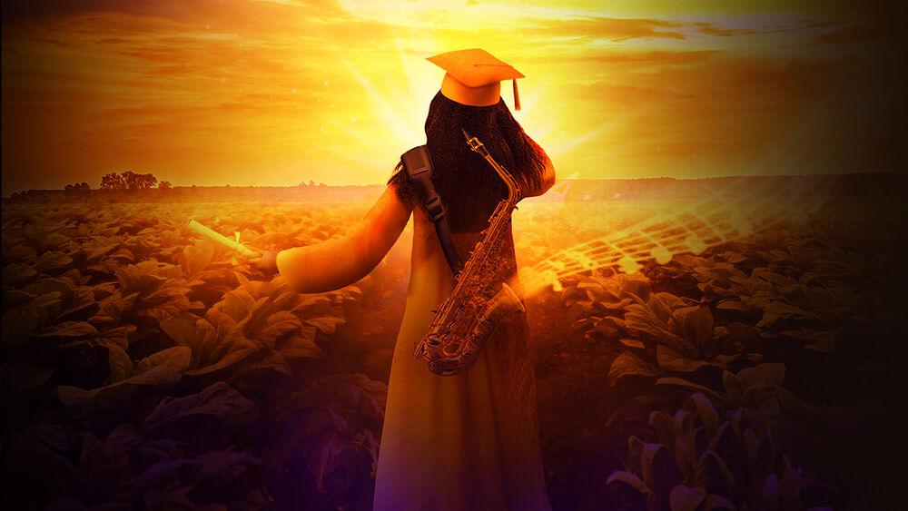 A person in graduation cap and gown, holding a rolled paper, looking out over a field of crops. The image filtered in yellow.