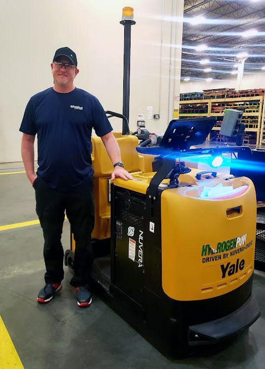 Brian Ross standing by a forklift