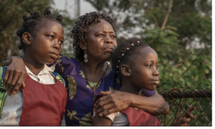 Woman and with her arms around her two daughters