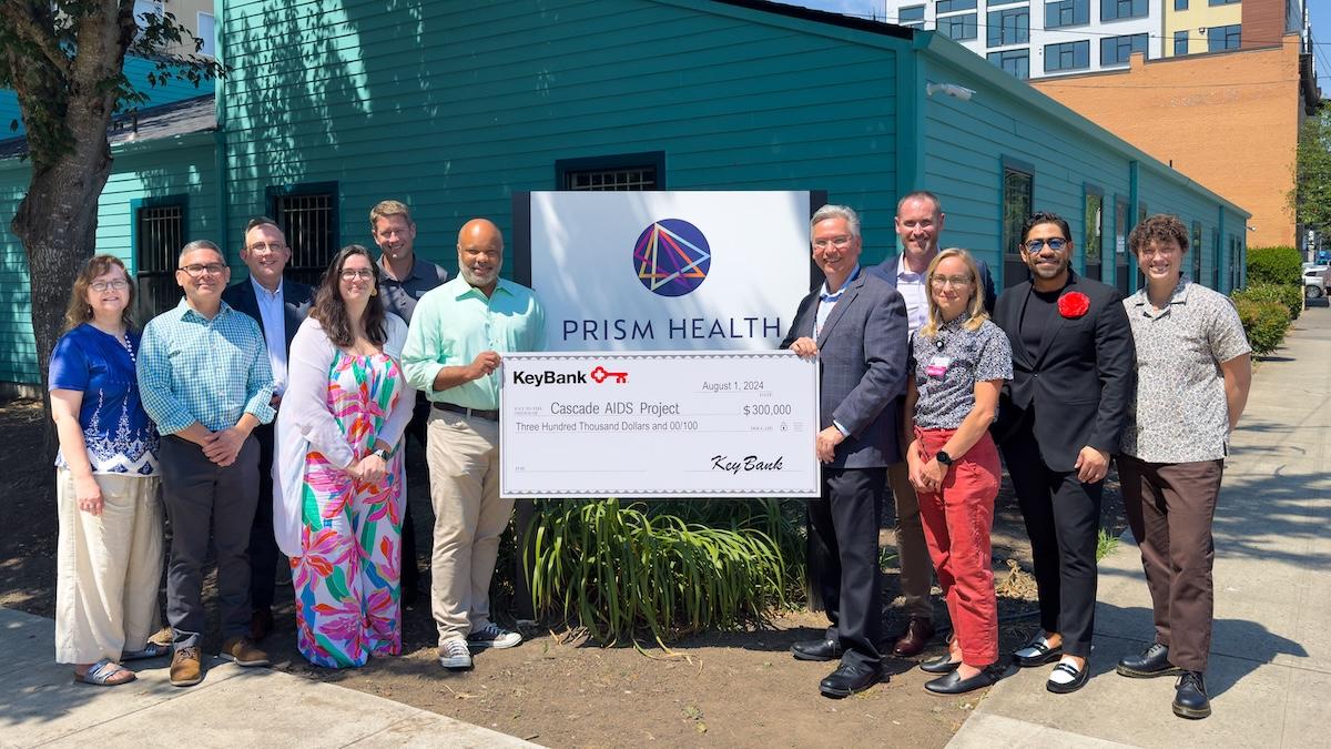 Representatives from PRISM Health and KeyBank holding a $300,000 grant check for the Cascade Aids Project.