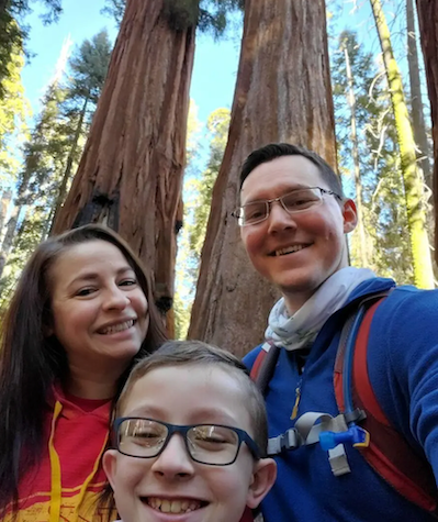 Calvin, his wife and son in a forest.