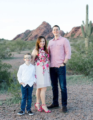 Calvin, his wife and son in the desert with a cactus in the background.