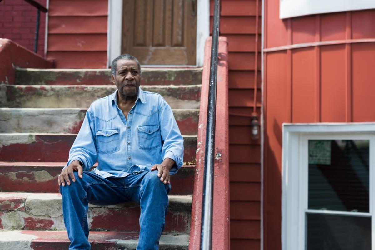 Resident seated in front of his home in NYC.