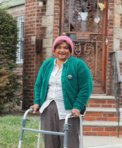 Female resident with a walker in front of her residence.