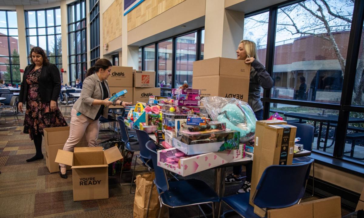 group putting toys in boxes