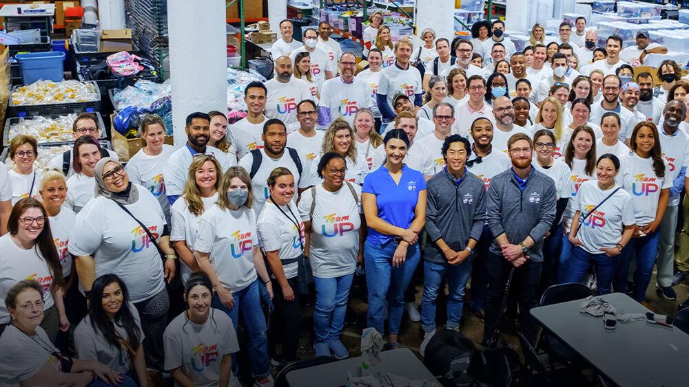 A large group of posed people, most in matching tshirts.