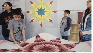 Students standing around colorful star design