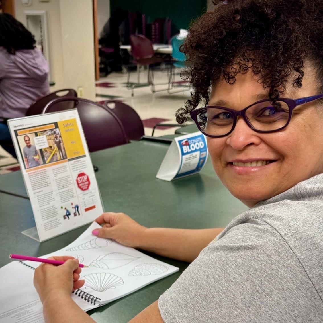 A woman coloring at Tapestry's Ohio fulfillment center