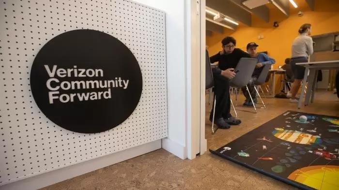 A Verizon Community Forward logo on a white wall