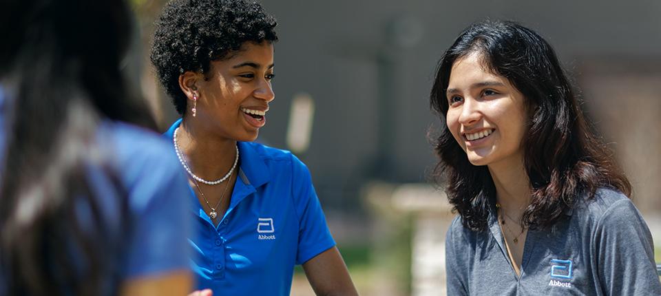 two smiling people wearing shirts with the Abbott logo