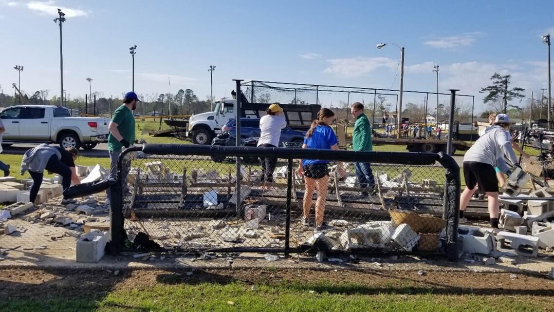 School and community members working to clean up the softball field.
