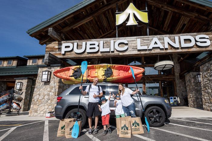 Jax Ramirez and his family pictured in front of Public Lands. A kayak is loaded on top of the family car.