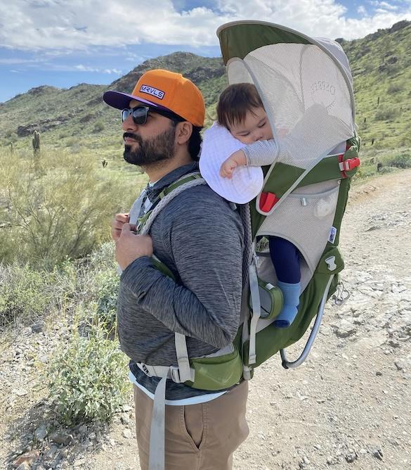 Daniel Leyba and his child asleep in a snuggie.