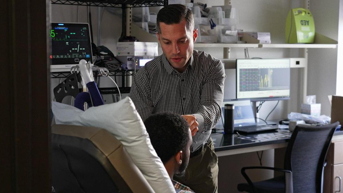 Image of lab manager attending to a patient 