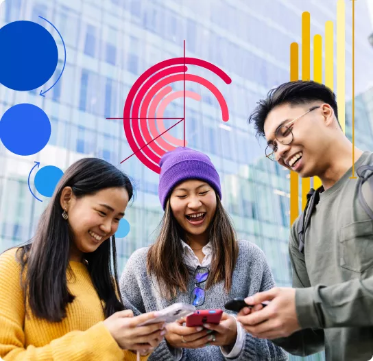 Three Asian people looking at their phones and smiling.