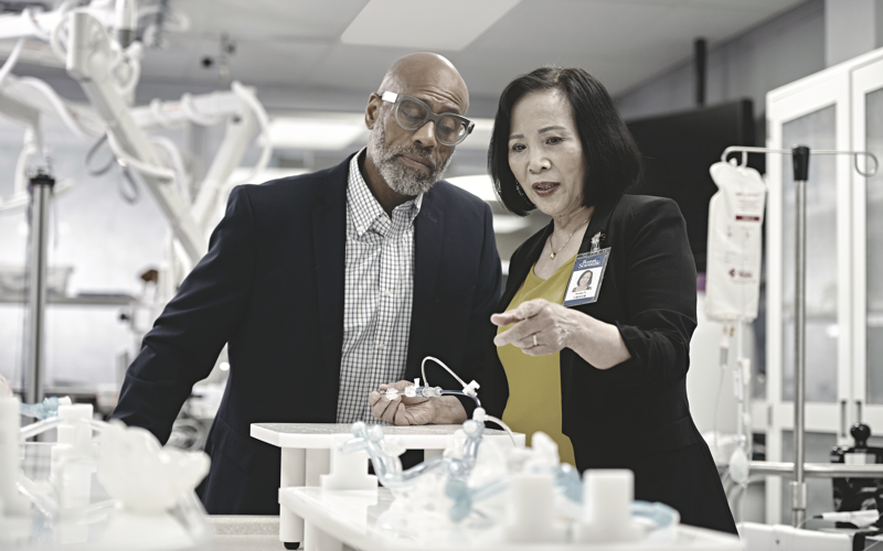 two individuals looking at medical equipment